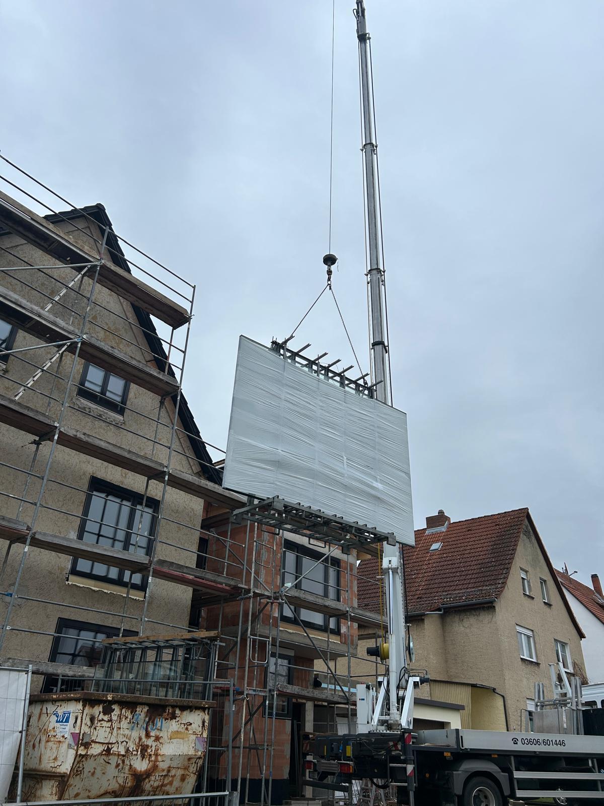 Großes Fensterelement wird per Kran an die Fassade gehoben